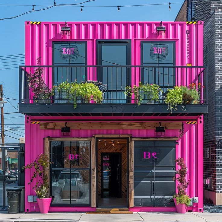 a pink building with plants on the balconies