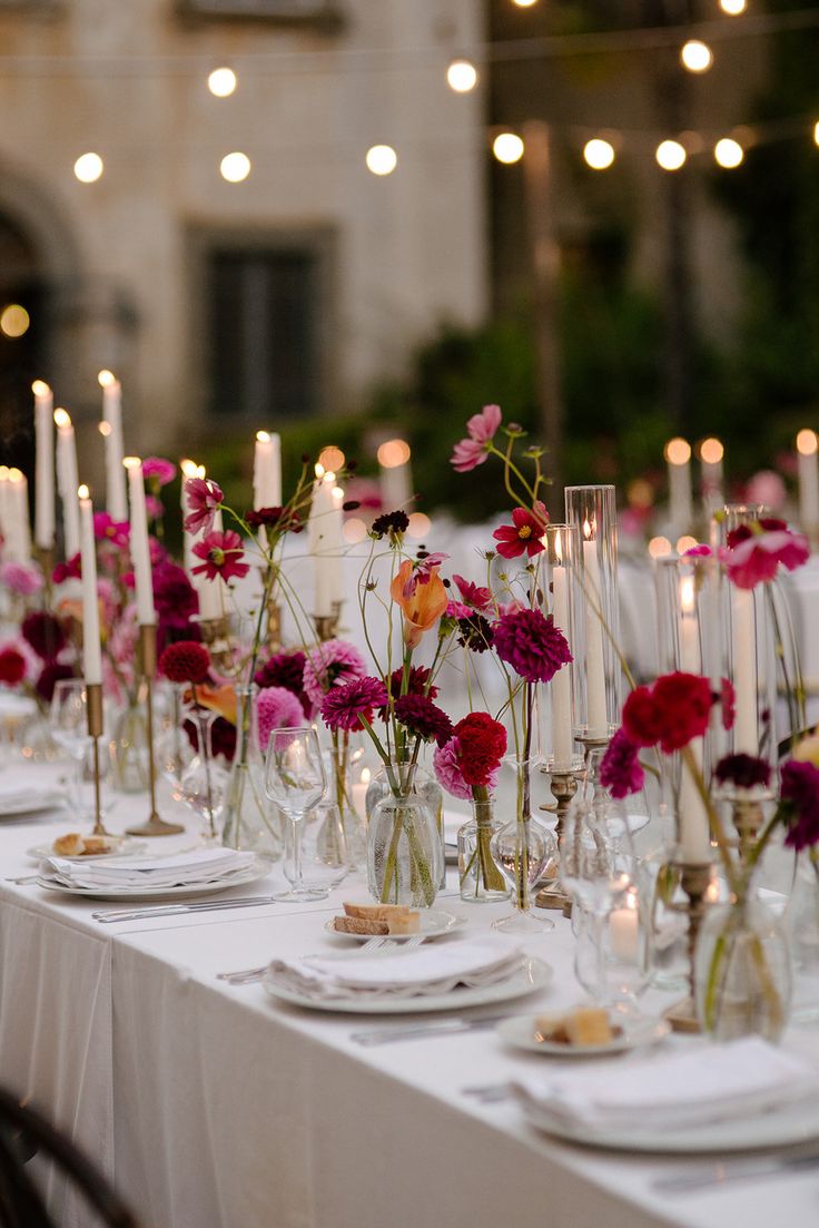 a long table is set with flowers and candles