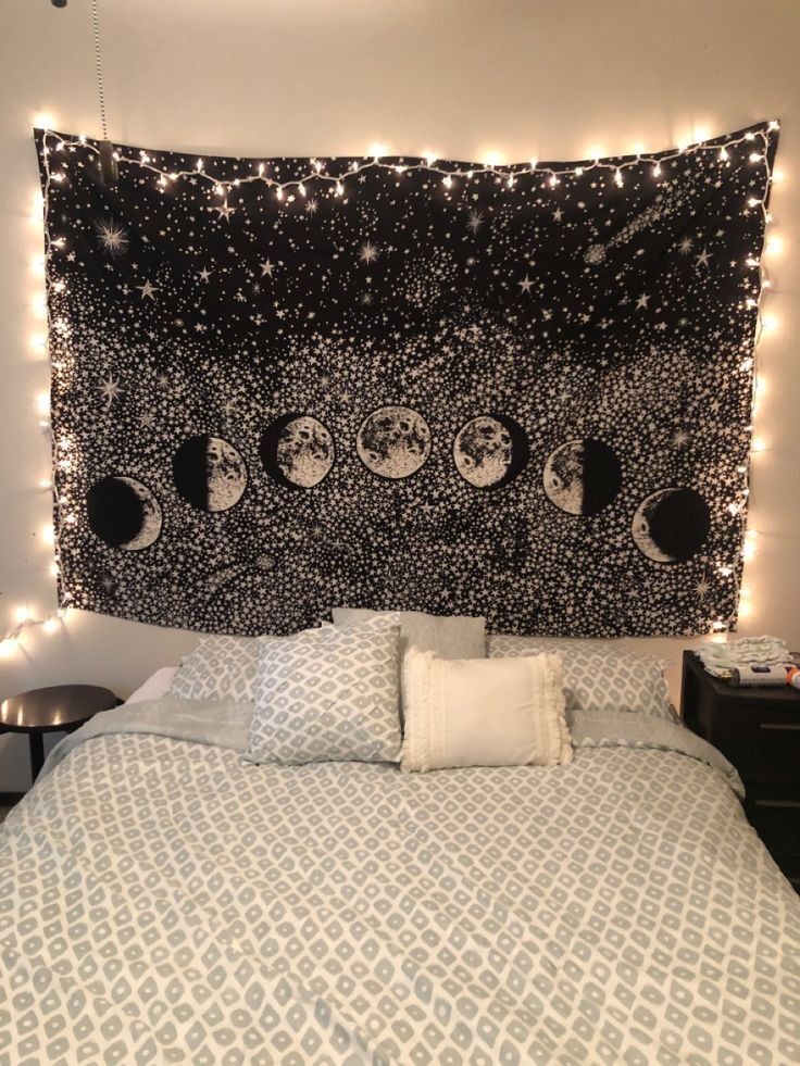 a bed with lights on the headboard and an image of the moon in the sky above it