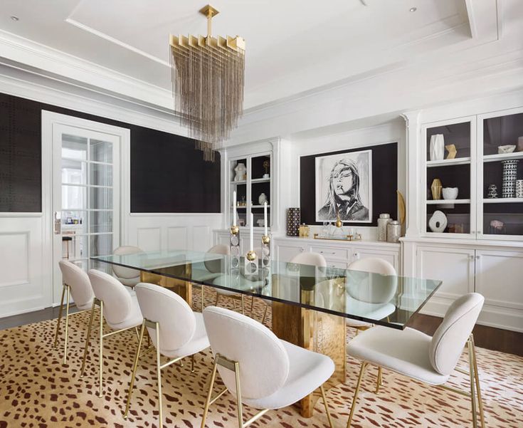 a dining room table with white chairs and a chandelier