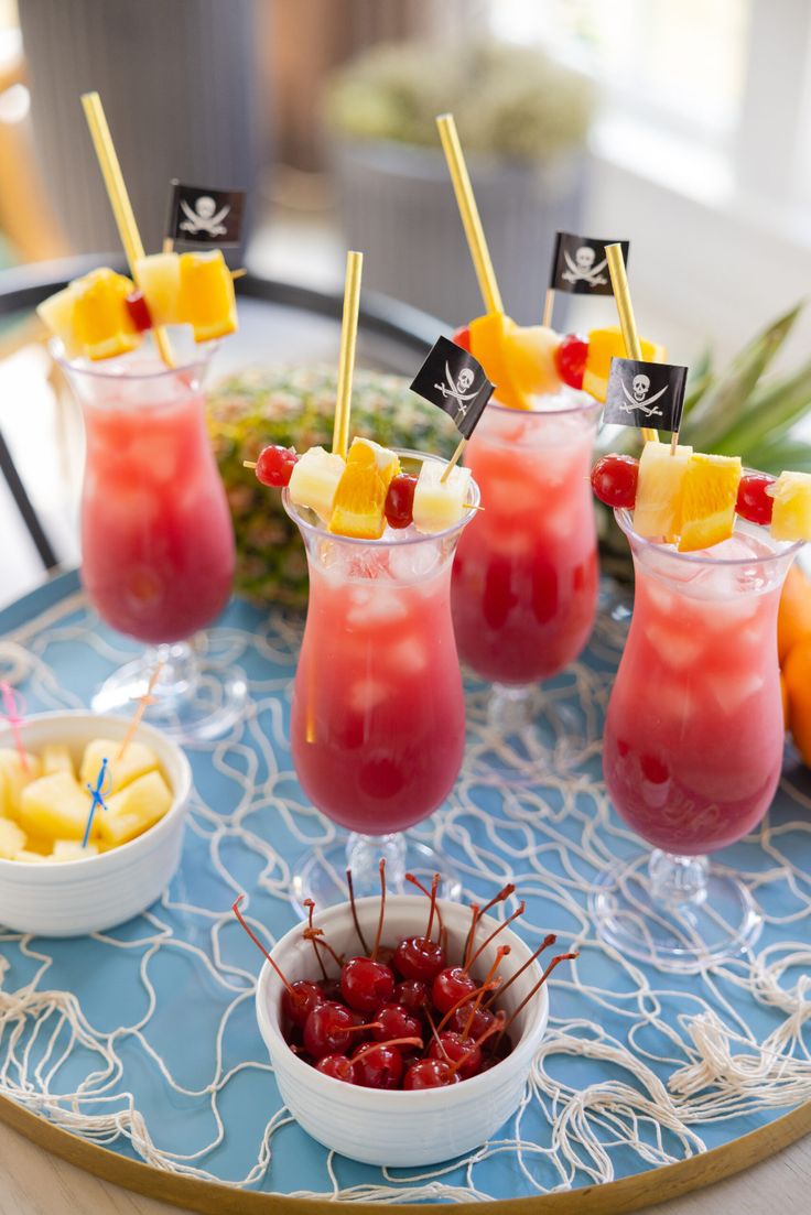 fruit cocktails with pineapple and cherries on a tray