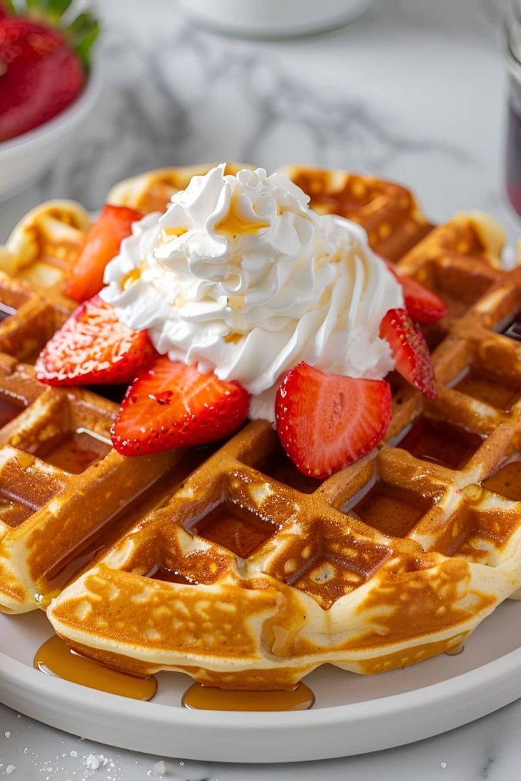 a waffle topped with whipped cream and strawberries