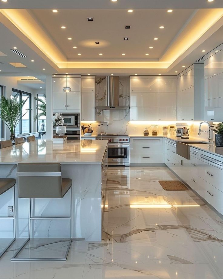 a large kitchen with white cabinets and marble flooring