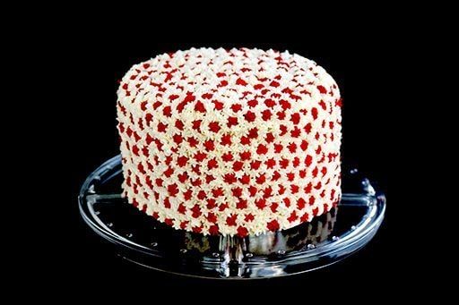 a red and white cake sitting on top of a glass plate