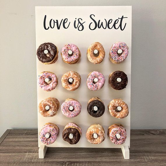 a sign that says love is sweet with donuts on it