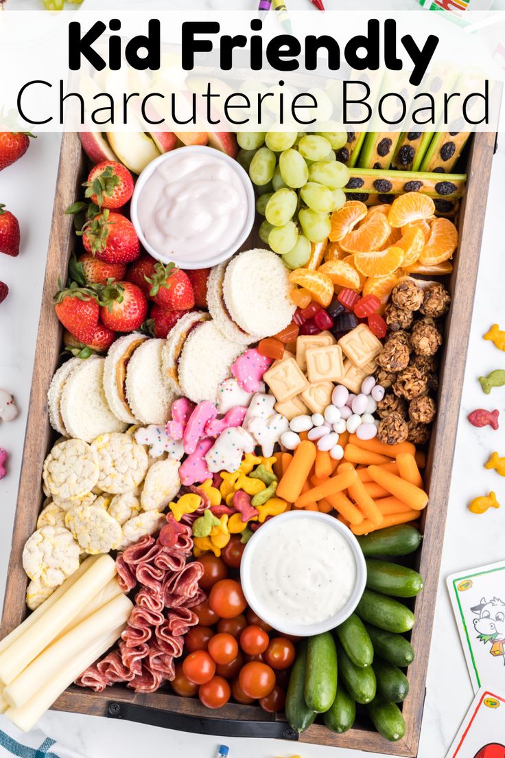 a kid friendly charcuterie board with fruit, vegetables and dips in it