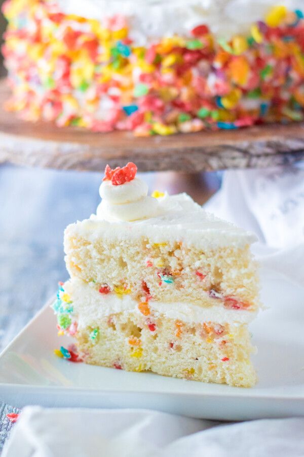 a slice of cake with white frosting and sprinkles