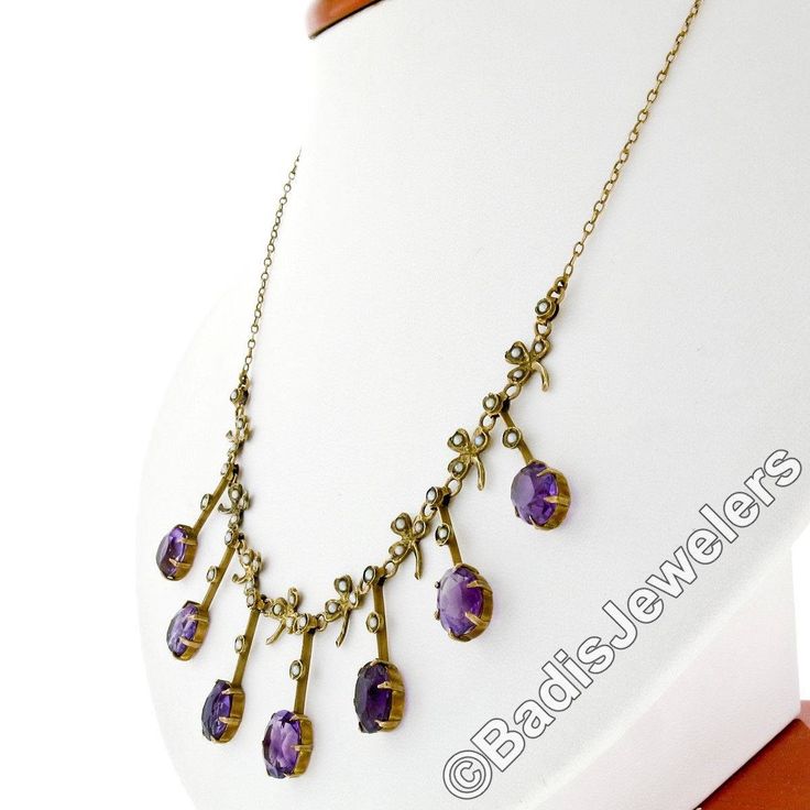 "You are looking at a rare antique collier necklace crafted in solid 14k yellow gold during the Victorian era. The center part of this beautiful necklace features elegant fringe designs alternating with clover leaf accents throughout. Each of these 7 dangle parts is set at its bottom with an old oval cut amethyst stone that shows amazing, rich purple color, and all 7 of them total approximately 14 carats in weight. The top of these fine gemstones, as well as the pretty leaf designs, are adorned Antique Oval Gemstone Necklace, Antique Amethyst Jewelry Stamped 14k, Antique Oval Purple Jewelry, Antique Purple Oval Jewelry, Antique Oval Purple Necklaces, Antique Purple 14k Stamped Jewelry, Antique Round Purple Necklace, Antique Purple Oval Necklaces, Antique Purple Necklace For Wedding