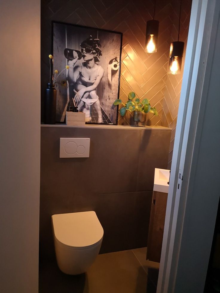 a bathroom with a toilet and pictures on the wall