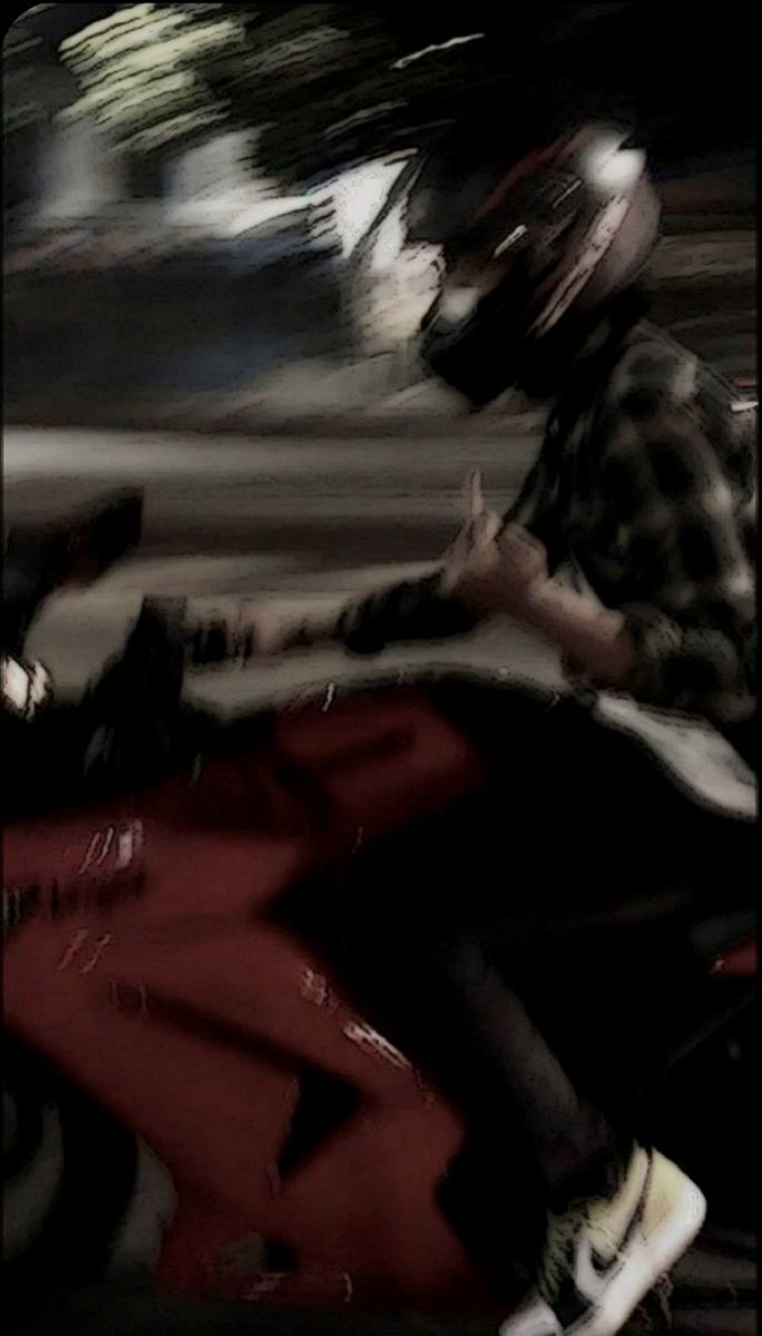 a man riding on the back of a red motorcycle