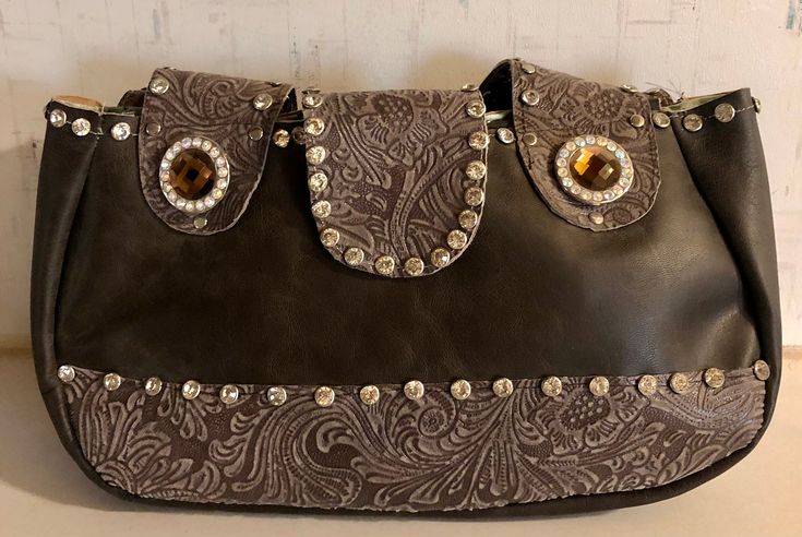 Up for your consideration is this handbag. This is done in brown leather. Has a lot of bling to it. This was made by me Western Wear Roxx. The inside is fully lined. There is a slot pocket & a zipper pocket. On the back there's a cell phone pocket. The clasp is magnetic. This measures 11 inches wide, 6 1/4 inches tall & 2 1/2 inches deep. The straps are 17 inches long. Nothing wrong with this. Any questions please ask. Thank you. Brown Clutch Bag With Snap Closure, Cowgirl Bling, A Cell, Western Wear, Bling Bling, 11 Inches, Purses And Handbags, Zipper Pocket, Shoulder Bags