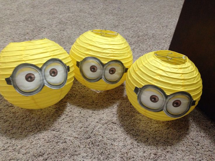 three yellow paper balls with eyes on them