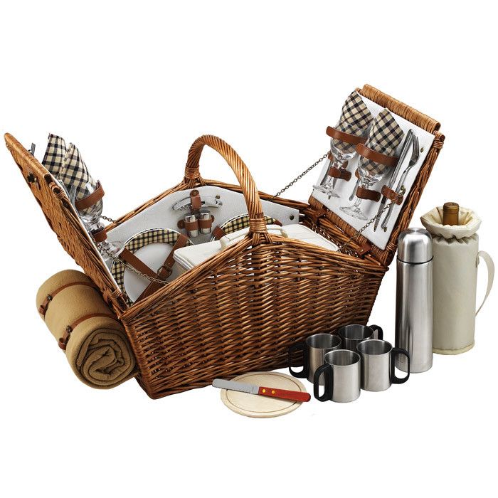 a wicker picnic basket filled with food and utensils next to coffee mugs