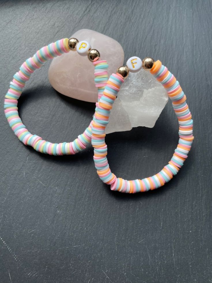 two bracelets sitting on top of a table next to a rock