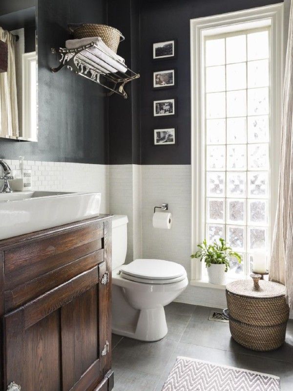 the bathroom is decorated in black and white with pictures on the wall above the toilet