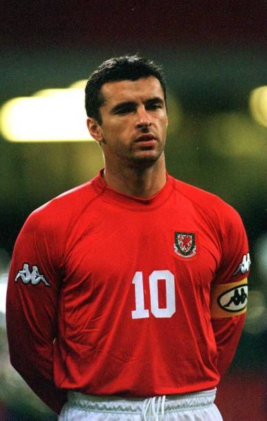 a man in a red shirt standing on a soccer field