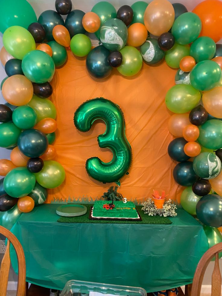 the table is set up with balloons and a number 3 sign on it for a birthday party