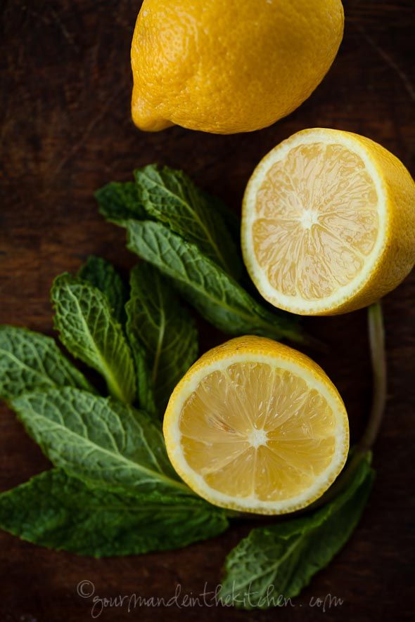 two lemons and leaves on a wooden table