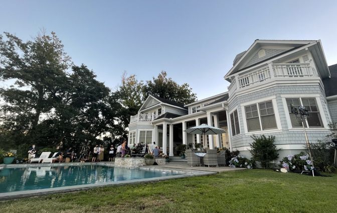 a large white house with a pool in the front yard