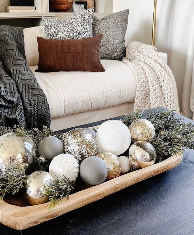 a tray filled with ornaments sitting on top of a wooden table next to a couch