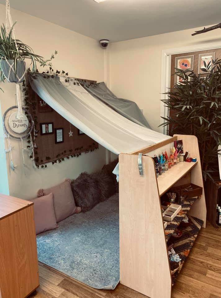 a room that has a bed with a tent over it and some plants in the corner