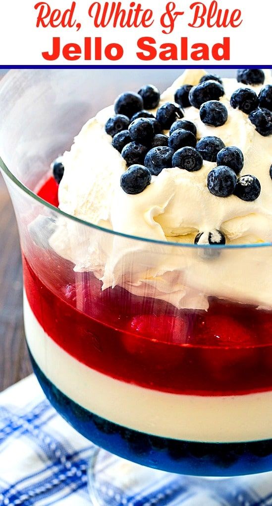 a red, white and blue jello salad in a glass bowl on a table