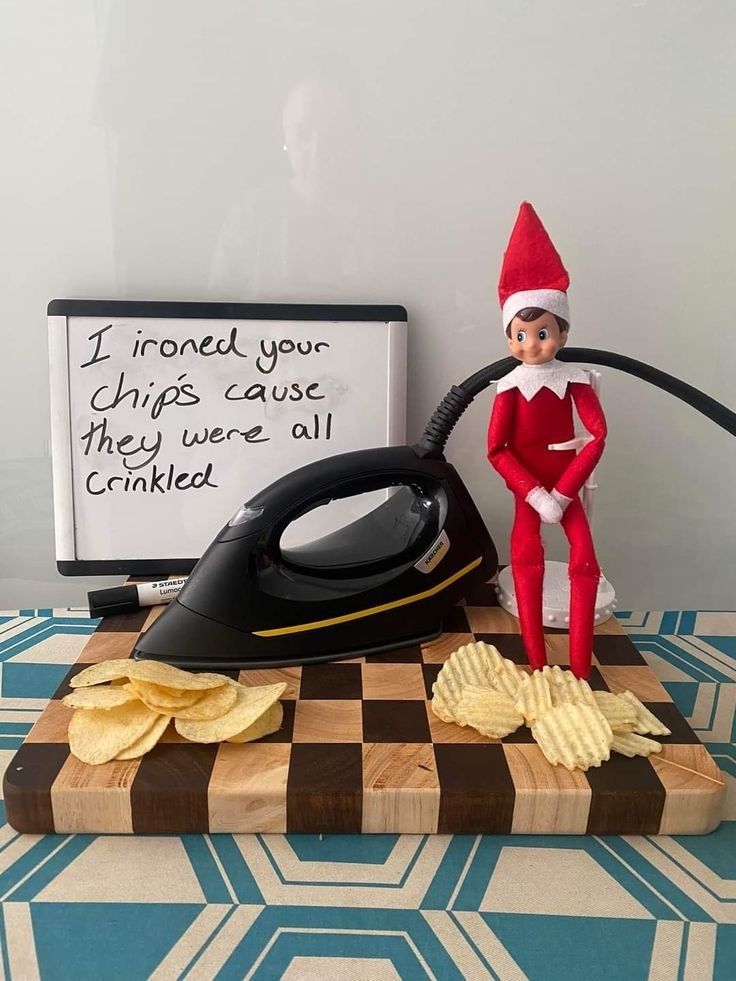 an elf is sitting on top of a table next to a black iron and chips