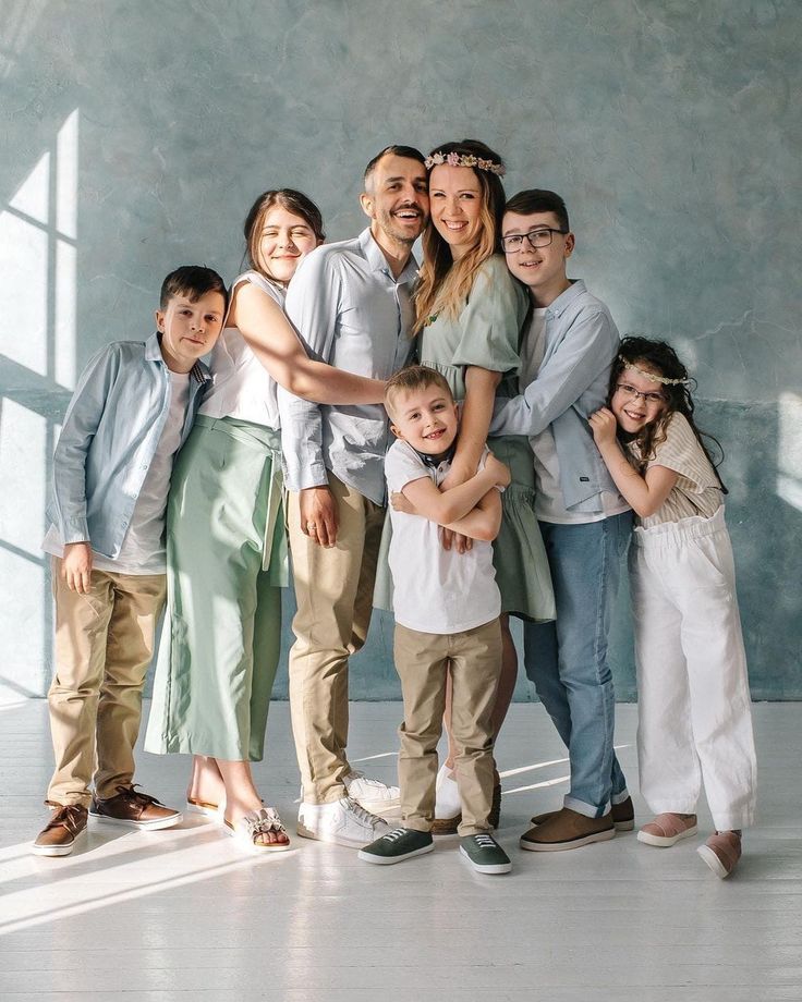 a family posing for a photo in front of a wall with the light coming through it