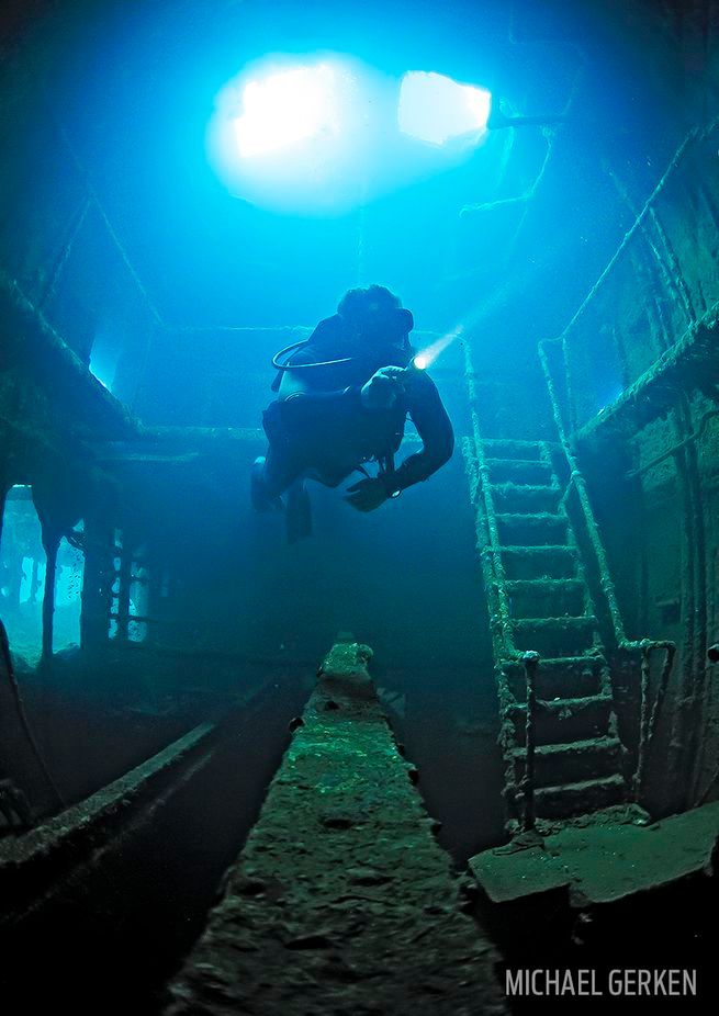 a scuba diver swims through the deep blue water