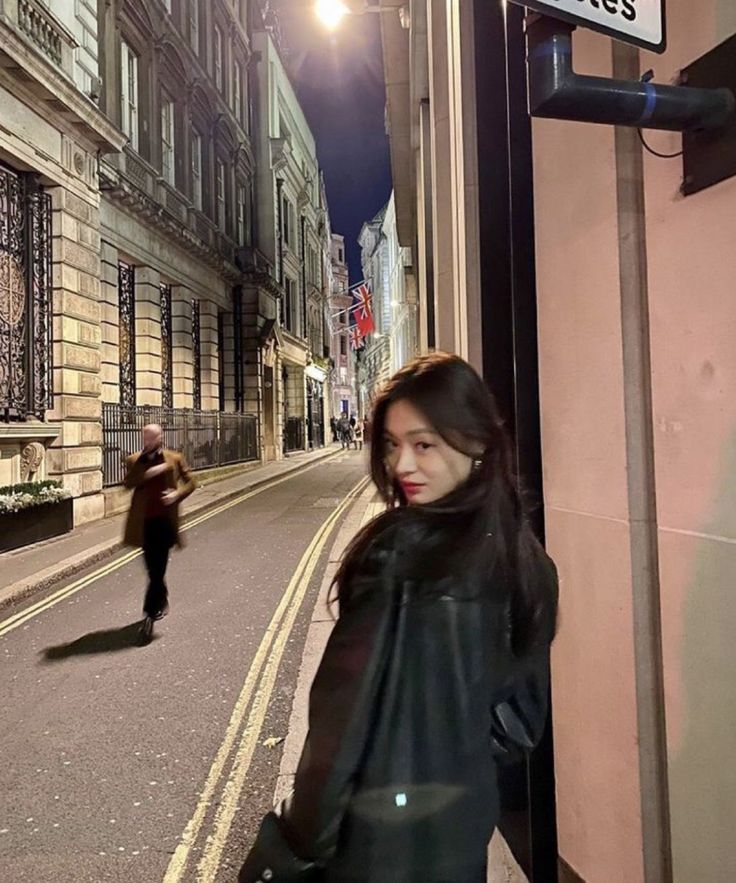 a woman standing next to a street sign