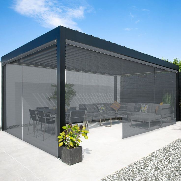 a patio covered in black plastic furniture next to a table and chairs