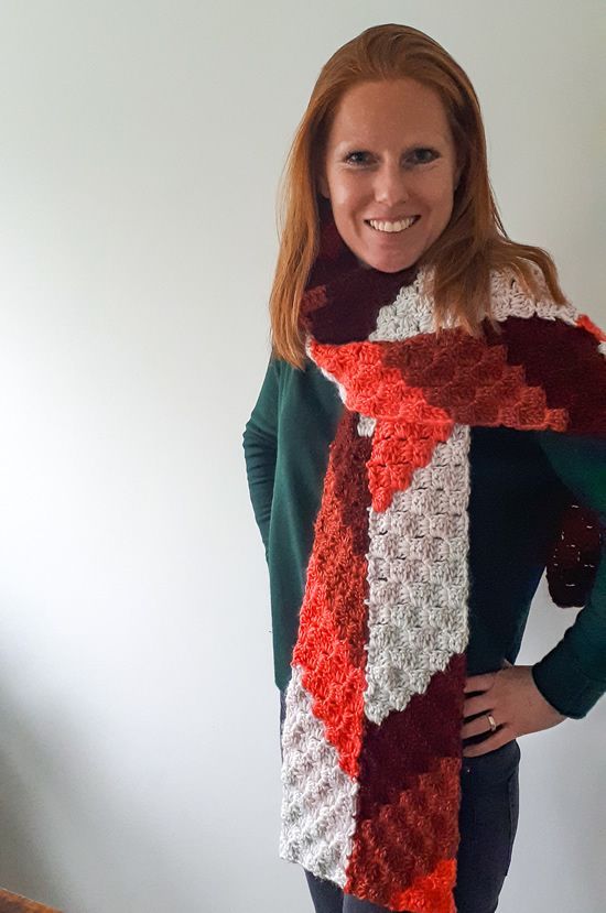 a woman wearing a red and white crocheted scarf