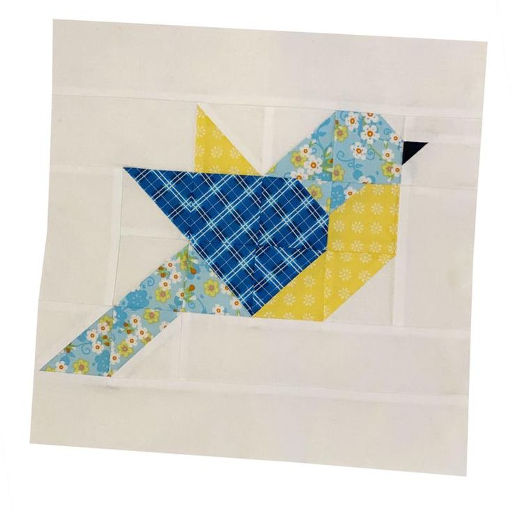 the bird is made out of fabric and has blue, yellow and white designs on it