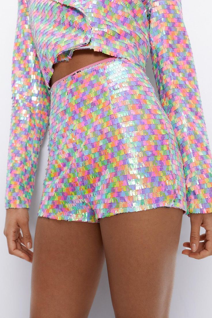 Where's the party? Feel fierce in our sequin shorts, made in shimmering sequin fabric, with a statement micro length and bodycon fit, and a fun rainbow colorway. The high waistline ensures your comfort and an ultra flattering fit, while the micro length and bodycon fit will turn heads. Pairs well with the matching sequin cropped blazer, or with a crop top for a more pared down approach. Perfect for discoball dancefloors, festival weekends, pride events, and rave nights. Multicolor Sequin ... Party Pants With Built-in Shorts, Summer Party Pants With Built-in Shorts, Sequin High-waisted Shorts For Summer, Fitted Multicolor Party Shorts, High-waisted Sequin Shorts For Summer, High Waist Sequined Bottoms For Summer, Disco Stretch Shorts, High Waist Sequined Summer Bottoms, Disco Style Stretchy Shorts