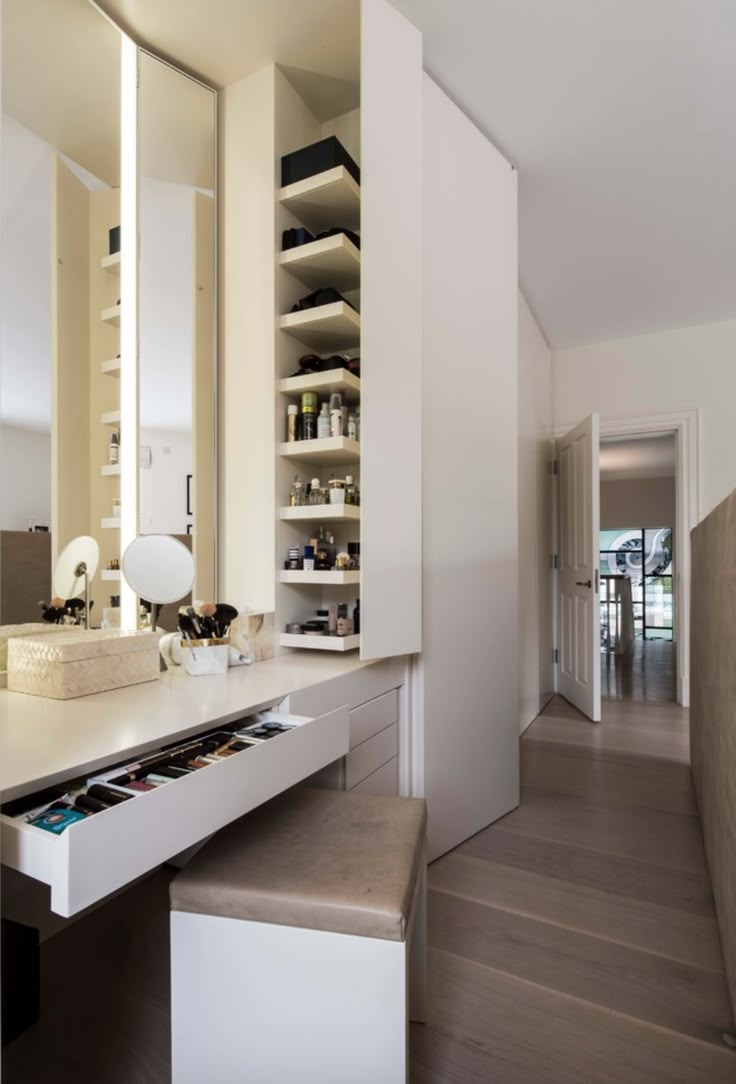 a white vanity with drawers and lights in a room that looks like a modern home