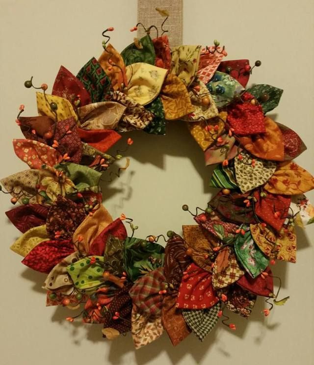 a wreath made out of fabric is hanging on the wall