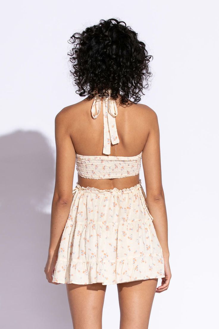 STYLE INFORMATION: Get your Texas boho vibes on in the Sundown Peach Floral Print Sundress!. Peach floral print Swiss dot fabric shapes this cute dress that has a halter V-neckline with tie straps, and a cutout waist.. The open back wraps around to the sides to create a cutout effect above the attached mini skirt. Ruffle trim and side ties decorate the cutout waist. DETAILS & CARE: Rayon/Polyester. Dry Clean. Imported. SHIPPING: We offer free shipping for all orders in the Continental US. Spring V-neck Halter Dress With Crisscross Straps, Spring Mini Dress With Wrap-around Straps, Spring Mini Dress With Tie Straps And Halter Neck, Spring Sundress Halter Dress With Adjustable Straps, Summer Triangle Halter Top With Wrap-around Straps, Spring Halter Neck Sundress With Adjustable Straps, Summer V-neck Tie Back Halter Top, Spring Wrap-around Straps Dress For Day Out, Summer Backless Halter Top With Wrap-around Straps