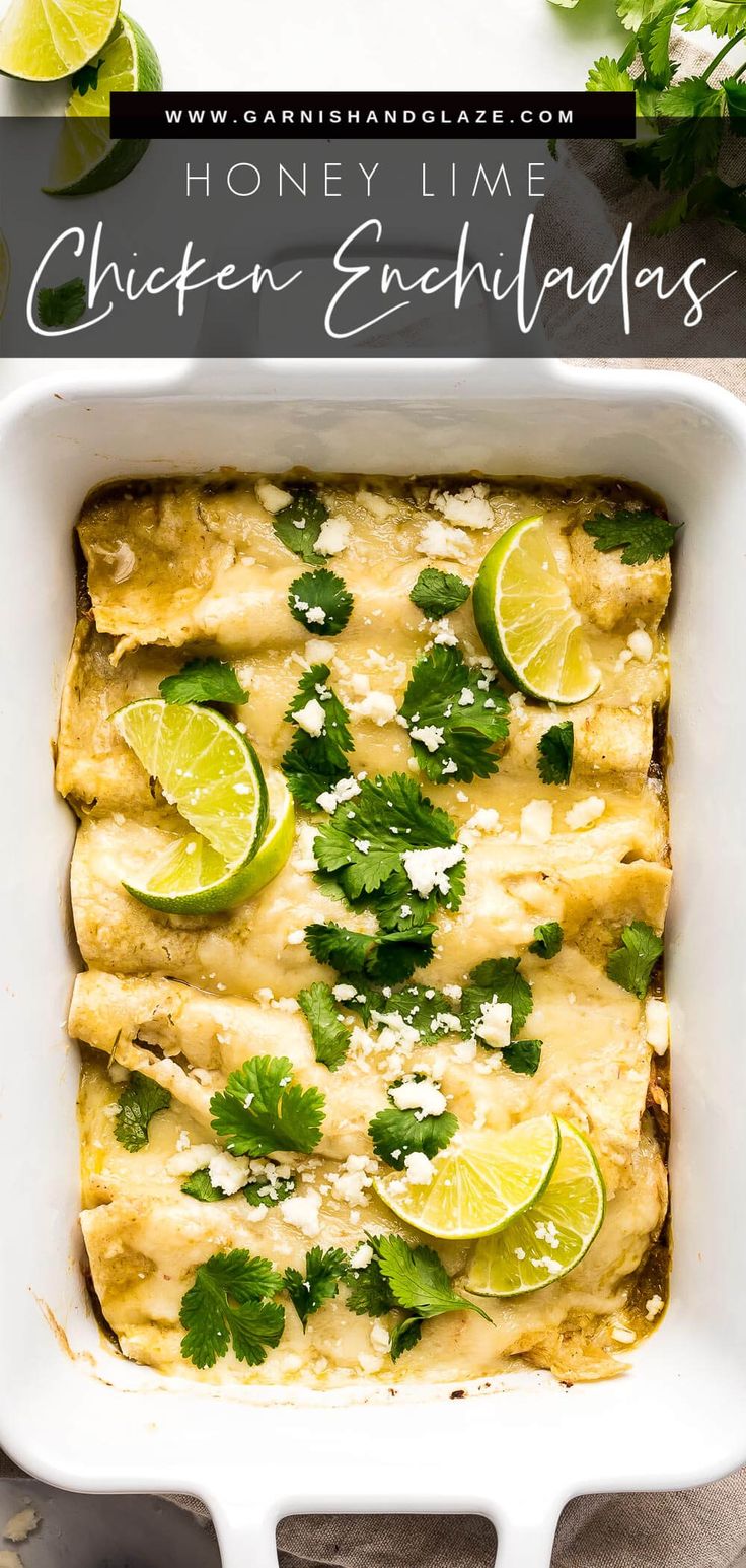 an enchilada in a white casserole dish with limes and parsley