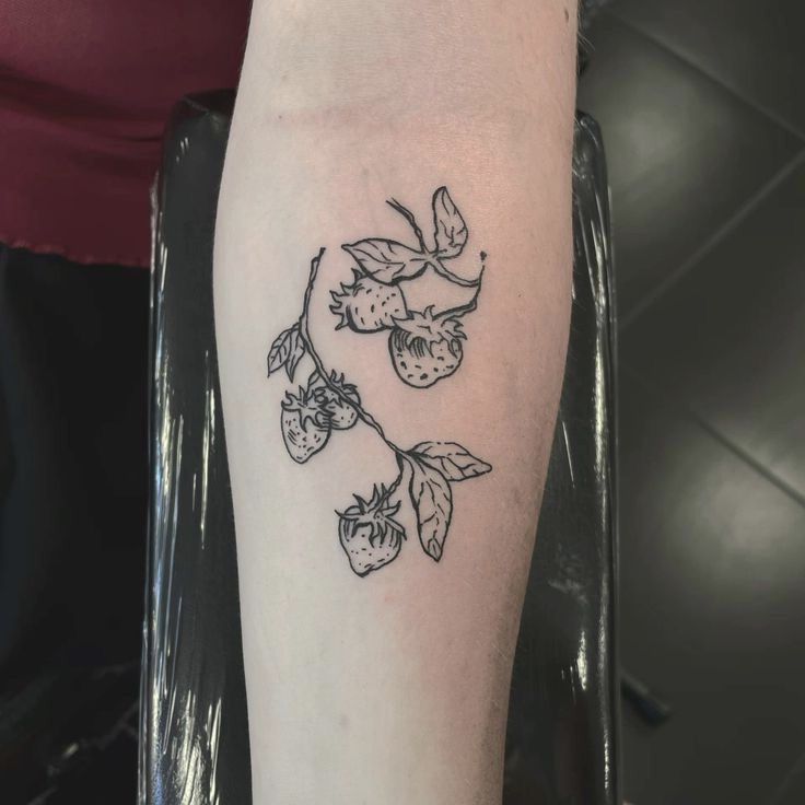 a black and white photo of a tattoo on the leg of a woman's arm