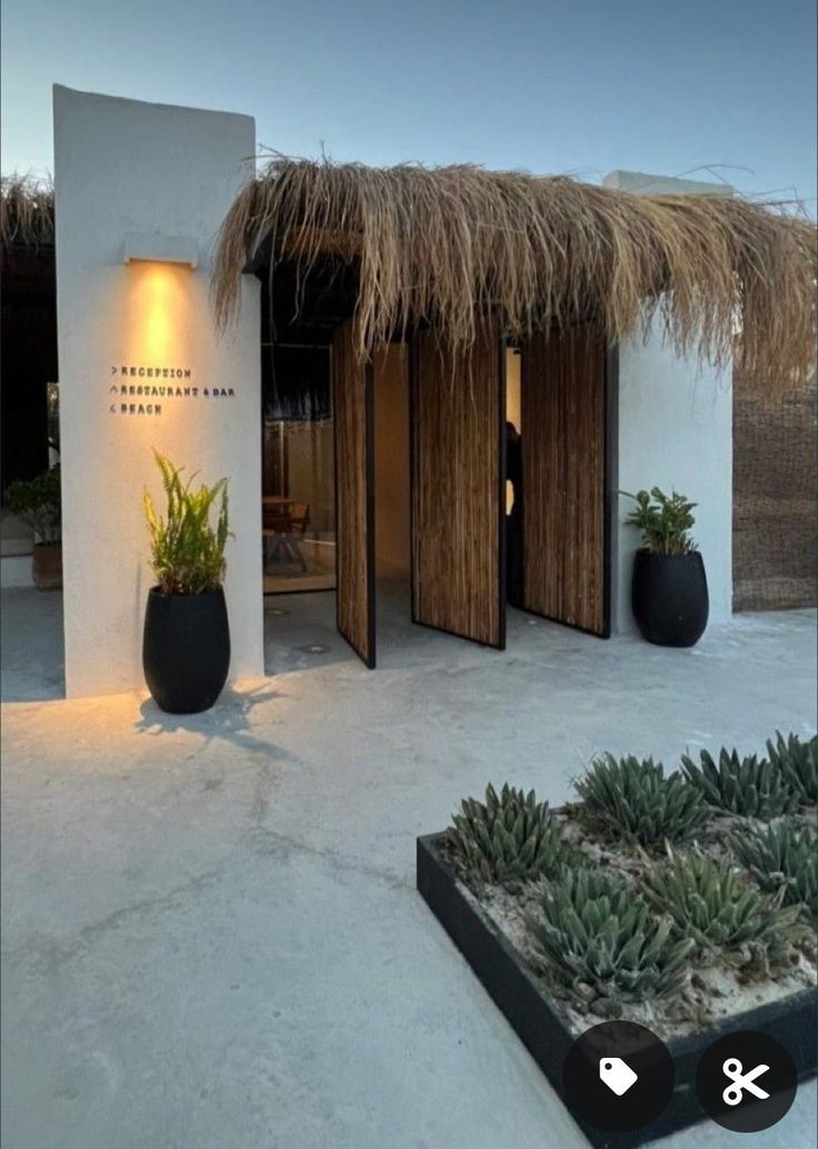 an outside view of a house with plants in the front yard and two potted plants at the entrance