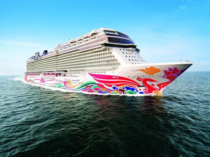 a large cruise ship in the middle of the ocean with colorful designs on it's side