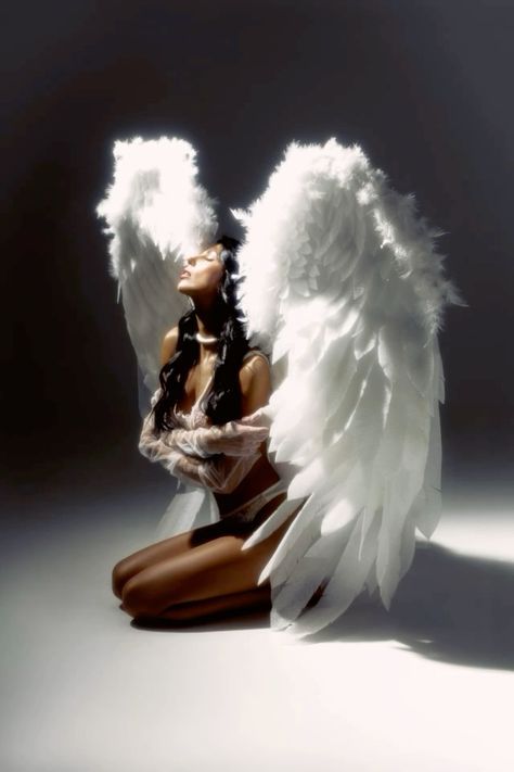 a woman with angel wings sitting on the ground