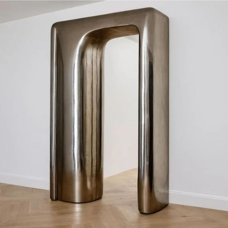 a large metal object sitting on top of a hard wood floor next to a white wall