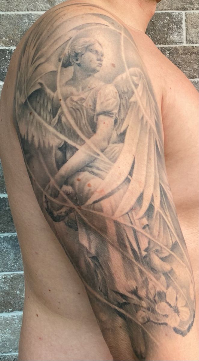 a man's half sleeve with an angel tattoo on his left arm and shoulder