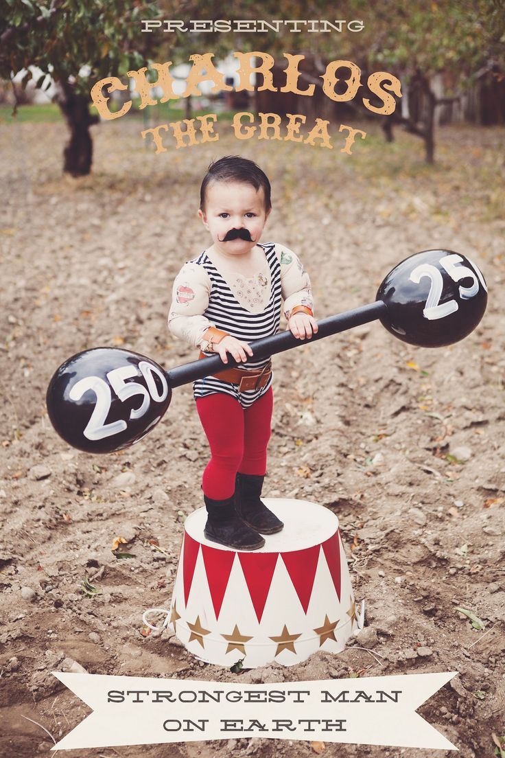 a little boy with a fake moustache on his face is standing on top of a circus tent