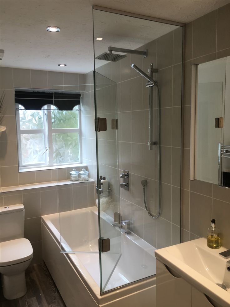 a bathroom with a sink, toilet and bathtub next to a window in it