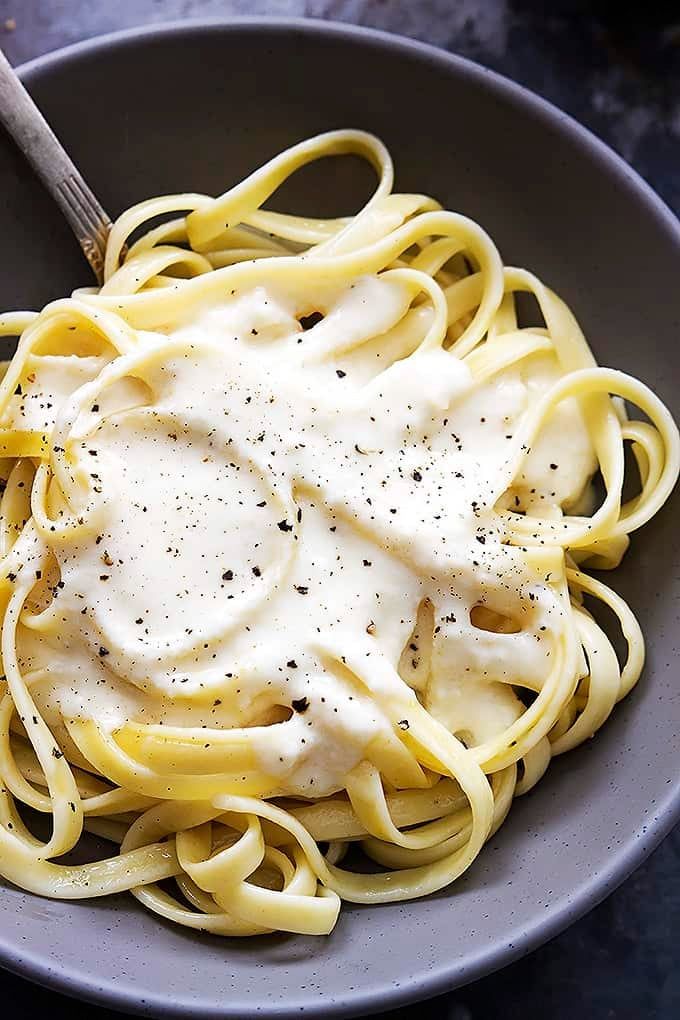 a bowl filled with noodles and sauce on top of a table