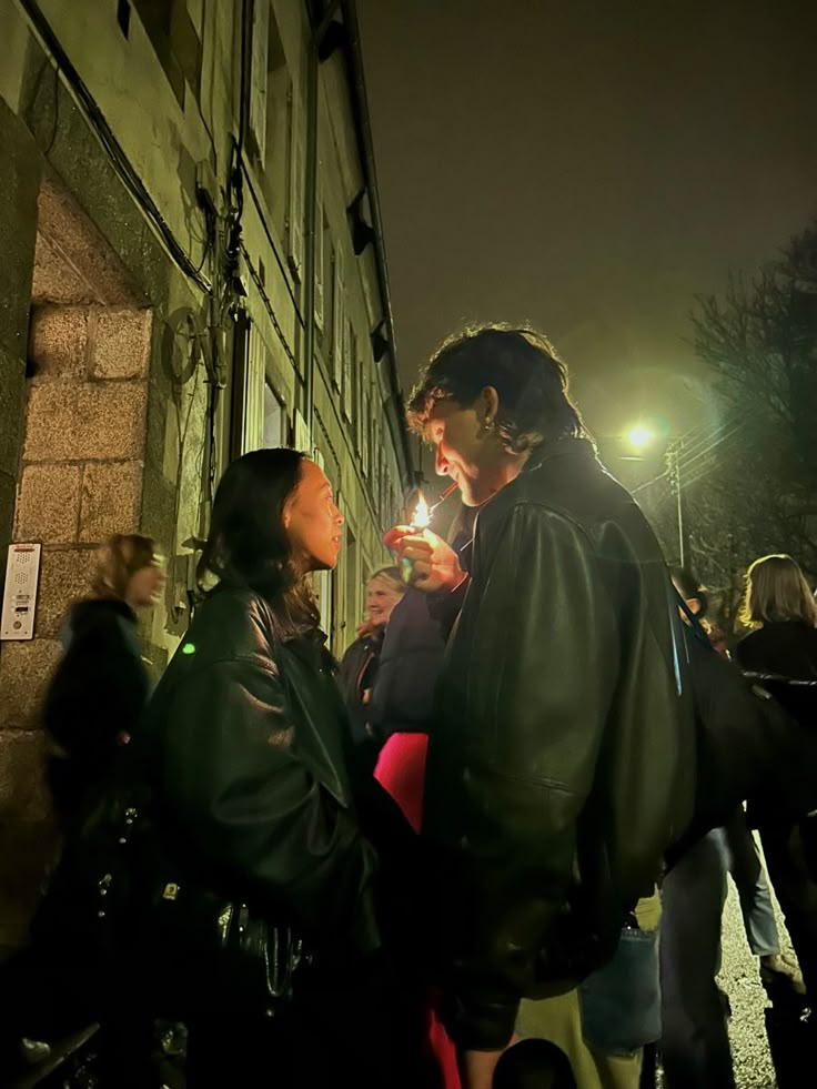 a man and woman standing next to each other holding lit sparklers in their hands