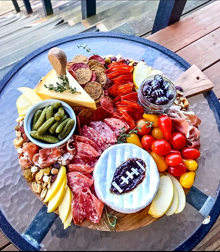 a platter filled with assorted meats and cheeses on a wooden table