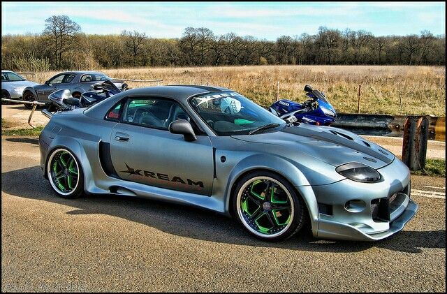 a silver sports car parked next to other cars